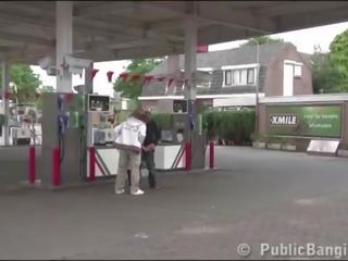 Mycket gravida ung kvinna offentlig trekanter vid en gas station